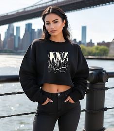 Elevate your style with our NYC Skyline Raw Hem Cropped Sweatshirt, a must-have for any fashion-forward woman. Made with combed and ringspun cotton and soft fleece material, this urban chic top features an iconic New York City skyline design, perfect for city lovers and casual nights out. Date night, Ladies night or just hanging out this trendy fashion forward Crop Top is sure to turn heads. Featuring unmistakable New York architecture within the stylish 'NY' design, the black white design on th Urban Fleece Tops With Letter Print, Trendy Fleece Top With Graphic Print, Ville New York, Skyline Design, Nyc Skyline, Casual Night Out, Chic Top, Cropped Sweatshirt, Ladies Night