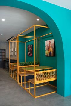 a room with green walls and yellow furniture on the floor in front of a blue arch