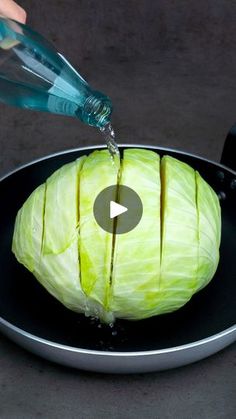 someone is pouring water on an apple in a frying pan that has been cut into pieces