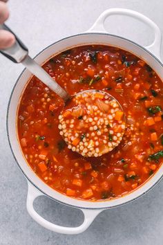 a spoon in a pot filled with soup