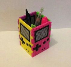 a pen holder made out of legos with pens and markers in the front, on a white surface