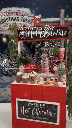 a hot chocolate stand is decorated with christmas trees and holiday signs in red, white and green