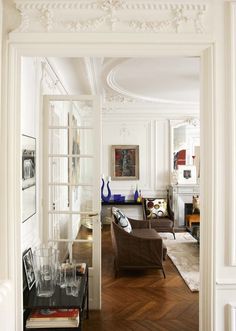 a living room filled with furniture next to a doorway leading into a kitchen and dining area