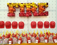 there are many red and yellow candies in bags on the table next to each other