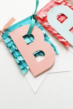 the letter b is made out of construction paper and ribbon, next to an origami birthday card