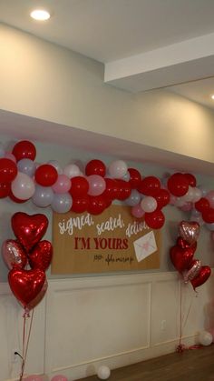 red and white balloons in the shape of hearts are on display at a valentine's day party