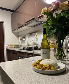 a bottle of wine sitting on top of a counter next to a plate of food