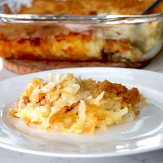 a white plate topped with food next to a casserole dish