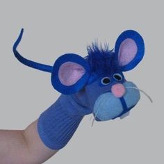 a hand holding a blue stuffed animal mouse