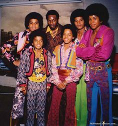 a group of people standing next to each other in front of a sign that says the jacksons