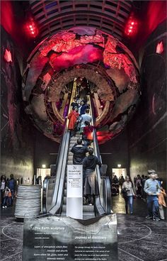 an escalator in the middle of a building with people walking up and down it