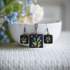 the earrings are decorated with blue flowers