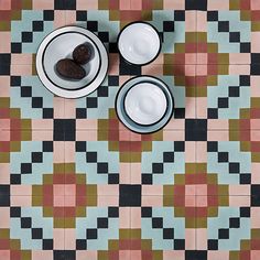 an overhead view of two bowls with cookies in them on a tablecloth that looks like checkered tiles