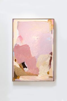 a painting hanging on the wall in front of a white wall with pink and yellow colors