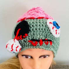 a mannequin head wearing a crocheted hat with eyeballs on it