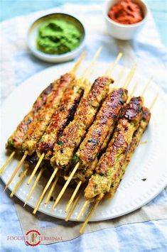 grilled chicken skewers on a plate with dipping sauce