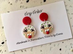 a pair of reindeer earrings with polka dots and red noses on top of a white card