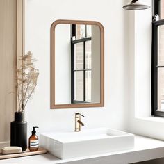 a bathroom sink sitting under a mirror next to a window