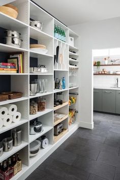 a kitchen filled with lots of white shelves