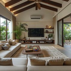 a living room with couches, tables and a flat screen tv on the wall