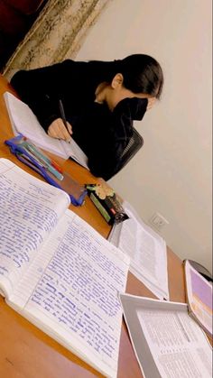 a woman sitting at a desk writing on paper