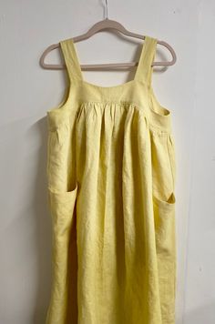 a yellow dress hanging on a white wall