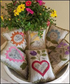 a bunch of pillows that have flowers in them