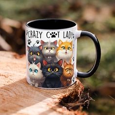 a coffee mug with cats on it sitting on a piece of wood