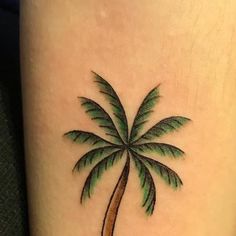 a small palm tree tattoo on the leg