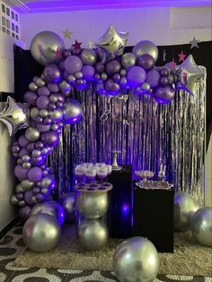 purple and silver balloons are on display at a party