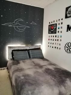 a bed sitting in a bedroom next to a wall with pictures on it and lights