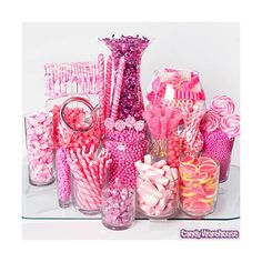 there are many pink and white candies in vases