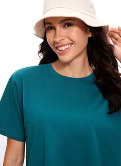 a woman wearing a green shirt and a white hat