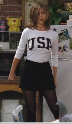 a woman standing in front of a refrigerator wearing tight black stockings and a white shirt with the word usa on it