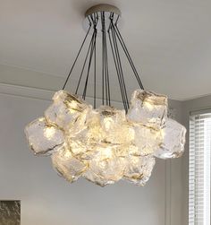 a chandelier made out of ice cubes hanging from the ceiling in a living room