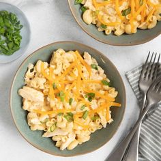 two bowls filled with macaroni and cheese on top of a table