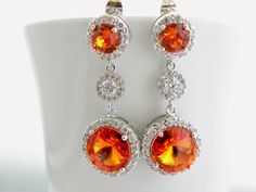 "Handmade Sterling Silver Earrings feature sparkly orange Swarovski crystals that are set in frames designed and made exclusively for Estylo Jewelry. These beautiful earrings are made of Crystallized Elements drops that hang from Sterling post earrings with matching orange Swarovski crystals surrounded by tiny clear Cubic Zirconia stones and round cubic zirconia connectors. They are perfect for a wedding or any other special occasion. They are gorgeous as focal point of your outfit. Also great f Orange Cubic Zirconia Jewelry For Anniversary, Orange Drop Earrings For Anniversary, Orange Teardrop Anniversary Jewelry, Orange Drop Earrings For Formal Occasions, Orange Teardrop Jewelry For Wedding, Orange Drop Earrings For Wedding, Fall Wedding Jewelry, Burnt Orange Wedding, Long Crystal Earrings