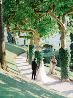 the bride and groom are walking down the path