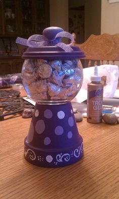 a purple container filled with candy sitting on top of a wooden table