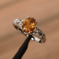 It is a natural citrine ring. The main stone is 7mm*9mm oval cut, weight about 1.77 carats. The basic metal is sterling silver and plated with rhodium. To change the metal to a solid gold (white/rose) or platinum is also available, please ask for a quotation if you want. You can also go to my shop Home for more elegant rings: https://www.etsy.com/shop/godjewelry?ref=hdr_shop_menu More citrine rings: https://www.etsy.com/shop/godjewelry?ref=seller-platform-mcnav&section_id=20715039 Customization Amber Engagement Ring, Citrine Wedding Ring, Silver Solitaire Engagement Ring, Yellow Gemstone Ring, Citrine Ring Engagement, Elegant Rings, Happy Families, Blue Aquamarine Ring, Marquise Cut Engagement Ring