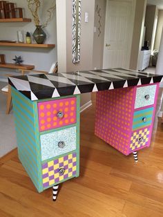 two colorful dressers sitting on top of a hard wood floor