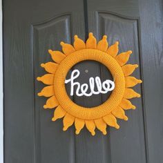 a knitted sunflower wreath with the word hello written on it in white yarn