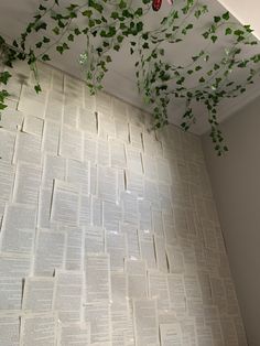 a room that has some plants growing on the wall and books hanging from the ceiling