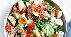 a bowl filled with salad and dressing on top of a table