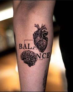 a person with a tattoo on their leg that says balance and two human heart halves