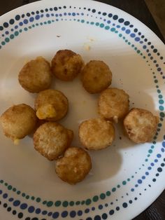 some fried food on a white plate with blue and green polka dot pattern around it