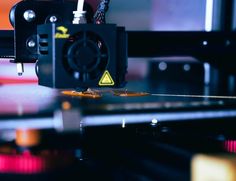 an image of a 3d printer being worked on by someone using the machine to print it