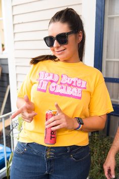 "Head Butch In Charge" screen-printed yellow shirt. Let everyone know who is really in charge with this fun shirt. Pre-shrunk, soft washed, garment dyed fabric Designed and made in New Orleans Unisex sizing Size Chart: (in inches) S M L XL 2XL 3XL Sleeve Length 8 8 ¼ 9 9 ½ 9 ¾ 9 ¾ Full Body Length 27 28 ½ 30 31 ½ 32 ¾ 33 Body Width 18 ½ 20 ½ 22 ½ 24 ½ 26 ½ 28 Yellow Pre-shrunk Tops For Fan Merchandise, Funny Yellow Top With Screen Print, Funny Yellow Screen Print Top, Retro Yellow T-shirt With Screen Print, Yellow Short Sleeve Screen Print T-shirt, Yellow Hip Hop T-shirt With Screen Print, Hip Hop Yellow T-shirt With Graphic Print, Yellow Short Sleeve T-shirt Pop Culture, Yellow Shirts