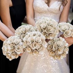 two bridesmaids are holding bouquets made out of book pages