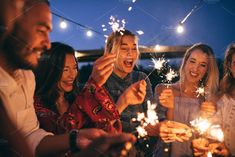 group of friends celebrating with sparklers at outdoor party